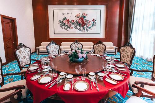 a dining room with a table with a red table cloth at GUOCE Beijing Capital Airport Hotel & Convention Center in Shunyi