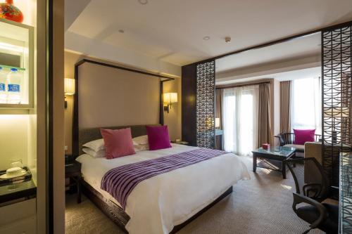 杭州的住宿－杭州西溪谷君亭酒店，卧室配有一张带粉红色枕头的大床