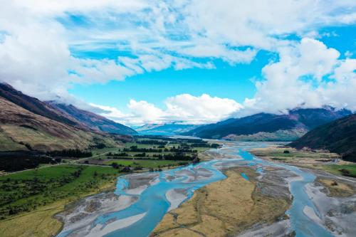an aerial view of a river in the mountains at Wonderland Makarora Lodge in Makarora