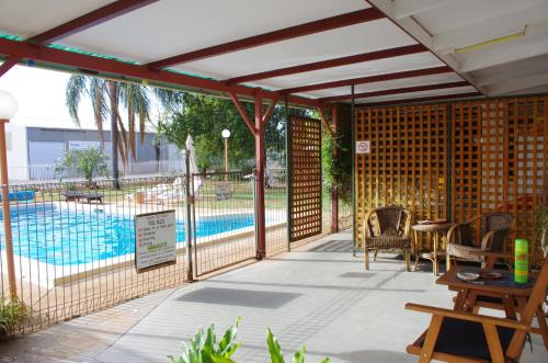 a patio with a pool and a table and chairs at Copper City Motel in Cobar
