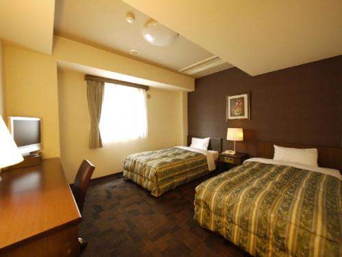En eller flere senge i et værelse på Hotel Route-Inn Iida