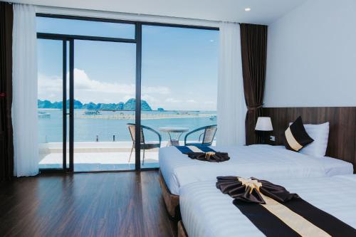 a hotel room with two beds and a view of the water at Sun Bay Tuan Chau Hotel in Ha Long