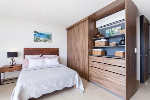 a bedroom with a bed and a large wooden cabinet at Riva Playasur 405 in Playa del Carmen