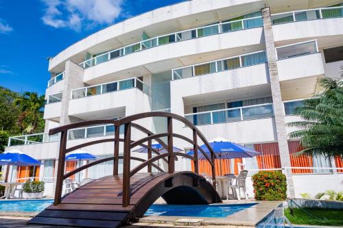 uma ponte sobre uma piscina em frente a um edifício em Apart Hotel Margherita em Natal