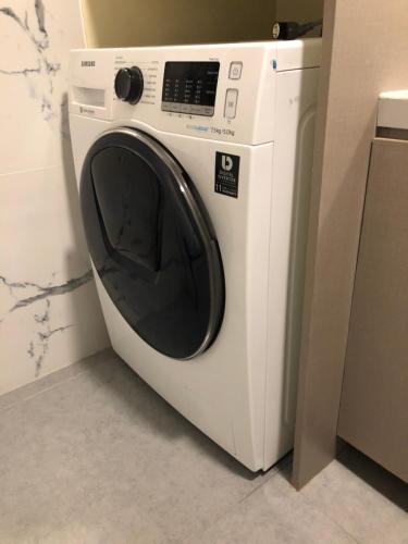 a white washing machine sitting in a room at Your Own 3 C's Space (Cozy, Clean and Convenient)! in Tagaytay