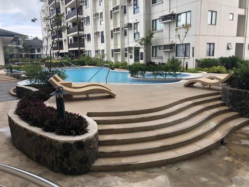 a swimming pool with stairs in a building at Your Own 3 C's Space (Cozy, Clean and Convenient)! in Tagaytay