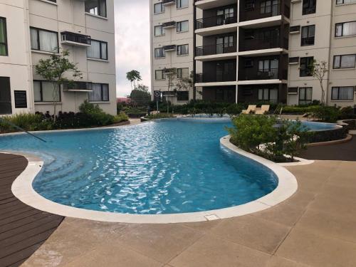 a swimming pool in front of two apartment buildings at Your Own 3 C's Space (Cozy, Clean and Convenient)! in Tagaytay