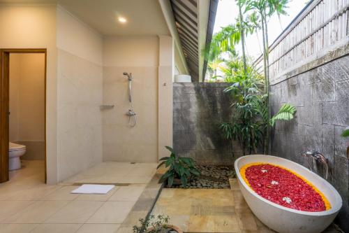 La salle de bains est pourvue d'une baignoire remplie de liquide rouge. dans l'établissement The Lovina, à Lovina