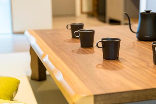 three coffee cups sitting on top of a wooden table at 博多町家ホテル - Kamigofuku - in Fukuoka