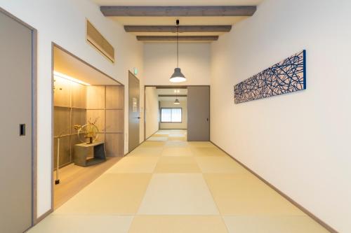 福岡市にある博多町家ホテル - Kamigofuku -のタイルフロアのオフィスビルの廊下