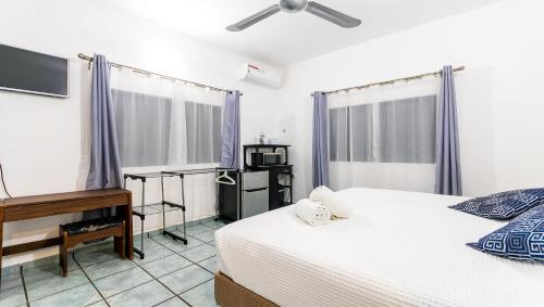 a bedroom with a bed and a desk and a piano at Vacation Rental - Upper Floor Room at Casa Cocoa in Cozumel