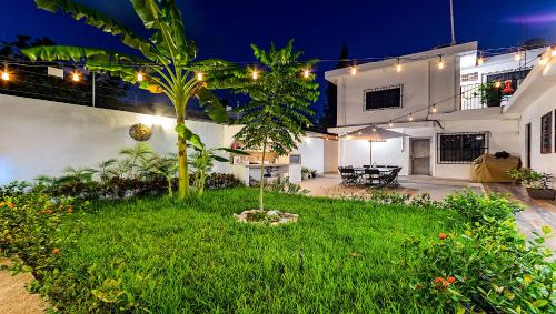a backyard of a house at night with lights at Vacation Rental - Standard Room at Casa Cocoa in Cozumel