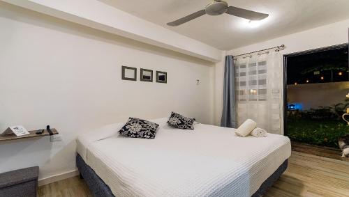 a bedroom with a bed with two pillows and a window at Vacation Rental - Standard Room at Casa Cocoa in Cozumel