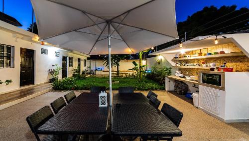 a patio with a table and an umbrella at Vacation Rental - Standard Room at Casa Cocoa in Cozumel