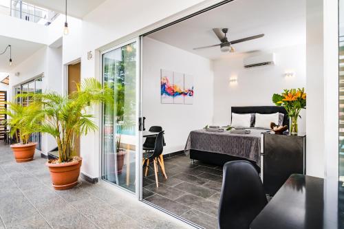 a bedroom with a bed and a balcony with plants at In the Shade Hotel - Coworking - 300Mbit - Adults Only in Tamarindo