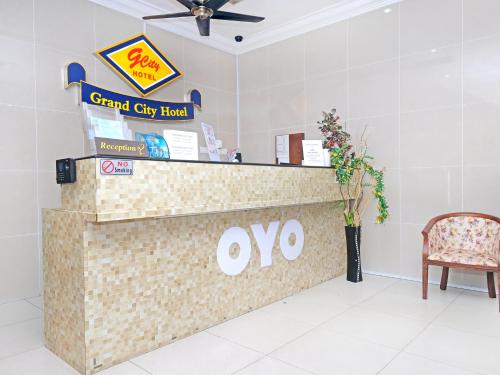 a front counter of a grand city hotel with a chair at Super OYO 546 Grand City Hotel in Kuantan
