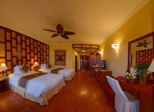 a bedroom with two beds and a ceiling fan at Chau Long Sapa 2 Hotel in Sa Pa