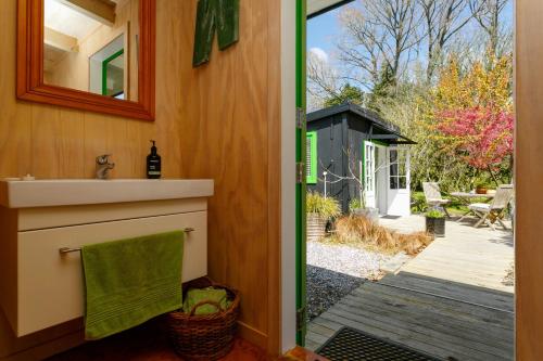 a bathroom with a sink and a door to a yard at Hare's Rest in Taupo