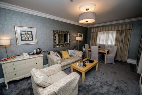 a living room with a couch and a table at Best Western Plus White Horse Hotel in Derry Londonderry