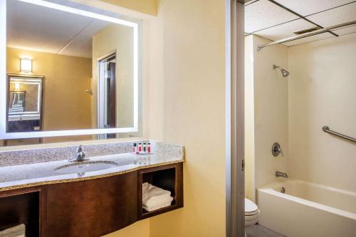 a bathroom with a sink and a mirror and a toilet at Howard Johnson by Wyndham Saugerties in Saugerties