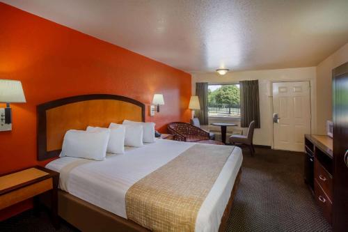 a hotel room with a large bed and a television at Travelodge by Wyndham Houston Hobby Airport in Houston