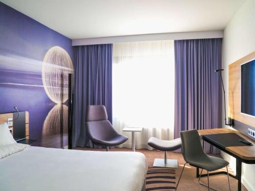 a hotel room with a bed and a desk at Novotel Katowice Centrum in Katowice