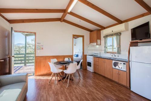 a kitchen with a table and chairs in a room at Discovery Parks - Lake Hume, New South Wales in Lake Hume