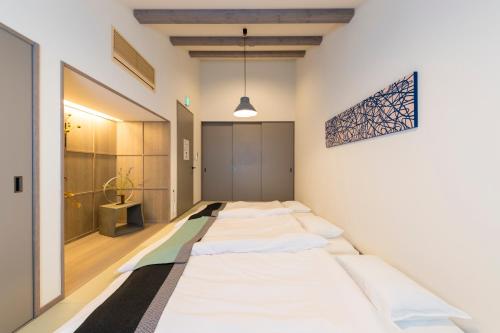福岡市にある博多町家ホテル - Kamigofuku -の一列のベッド
