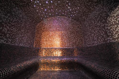 a room with a brick wall with a star ceiling at Hotel Nais in Niš