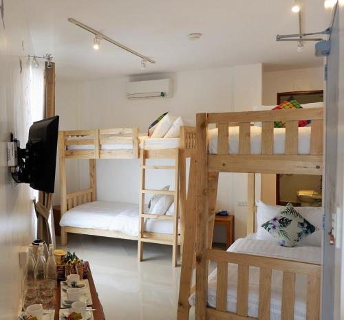 a room with two bunk beds and a television at Kamusta Boutique Hotel in Boracay