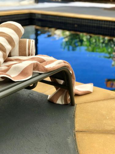 a towel is sitting on a chair next to a pool at Canterbury International Hotel in Forest Hill