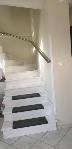 a stairway with white steps in a room at Alexia's Apartments in Rio