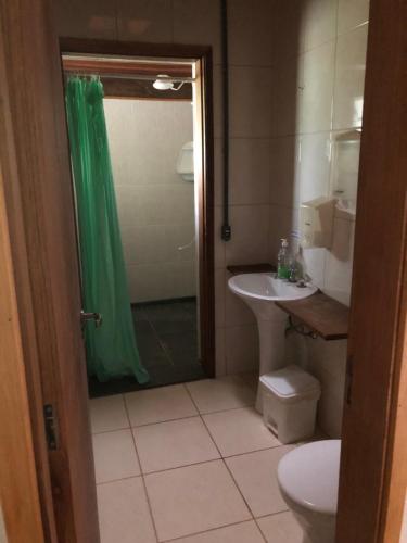 a bathroom with a shower and a sink and a toilet at Chácara Recanto in Bragança Paulista
