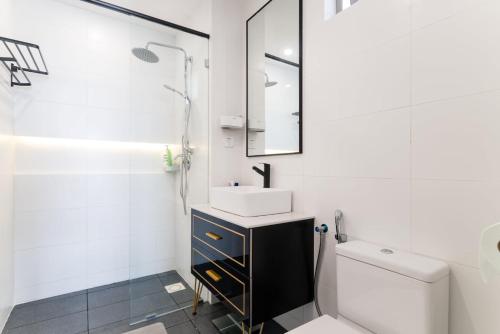 La salle de bains blanche est pourvue d'un lavabo et de toilettes. dans l'établissement Madam Design 1 at Kota Damansara, à Petaling Jaya