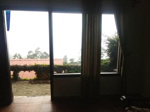 an open door to a room with two windows at Shamrock Holiday Home in Munnar