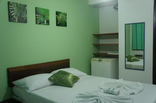 ein Schlafzimmer mit einem Bett mit einem grünen Kissen in der Unterkunft Pousada das Gaivotas in Bombinhas