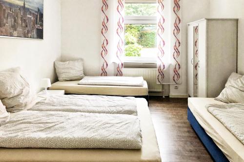 um quarto com duas camas e uma janela em Wunderschöne Altbauwohnung mit Flair in Wuppertal em Wuppertal
