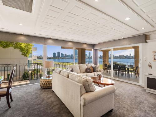 a living room filled with furniture and a balcony at The Peninsula Riverside Serviced Apartments in Perth