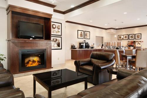 a living room with a fireplace and a television at Canalta Hotel Melfort in Melfort