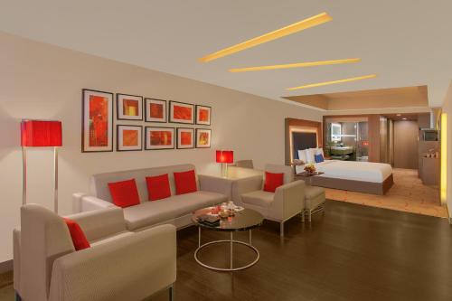 a living room with a couch and a bed at Novotel Ahmedabad in Ahmedabad
