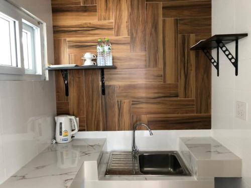 a kitchen with a sink and a wooden door at Pranee Amata in Ko Tao