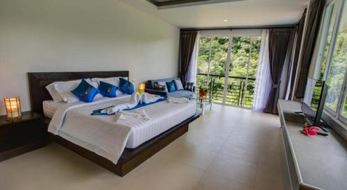 a large bedroom with a large bed with blue pillows at Kamala Amanah Hill in Kamala Beach