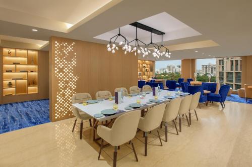 a conference room with a long table and chairs at Novotel Ahmedabad in Ahmedabad