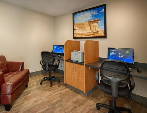 an office with two chairs and a desk with two computers at Canalta Jurassic in Drumheller