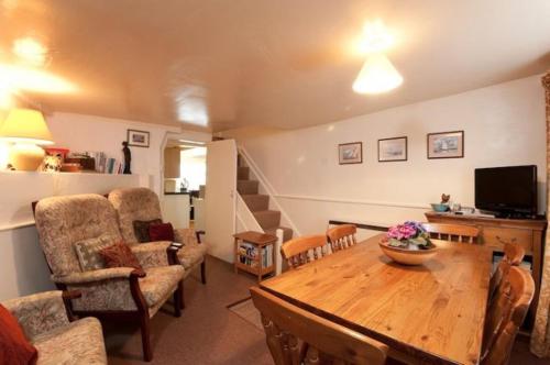 
a living room filled with furniture and a tv at Fishermans Cottage in Port Isaac
