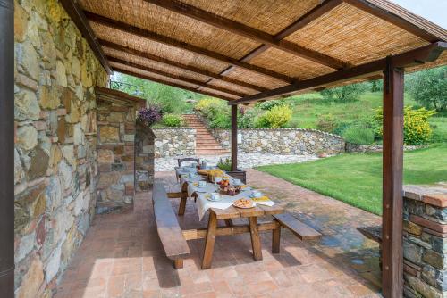a picnic table under a wooden pergola at Aurora Agriturismo in San Casciano dei Bagni