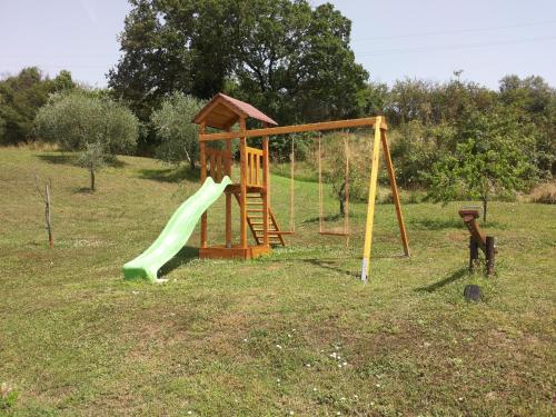 a playground with a slide in a field at Aurora Agriturismo in San Casciano dei Bagni