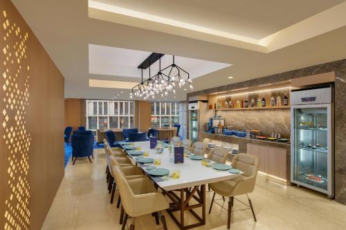 a dining room with a long table and chairs at Novotel Ahmedabad in Ahmedabad