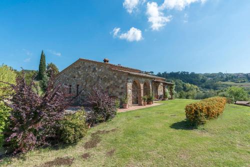 a large stone building with a grass yard at Aurora Agriturismo in San Casciano dei Bagni