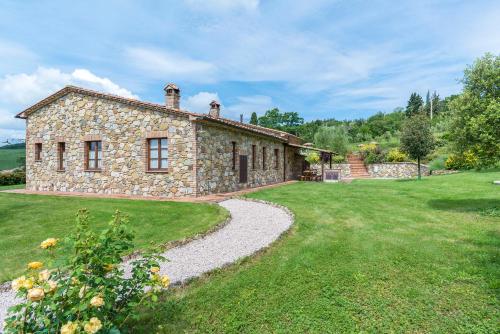 an external view of a stone house with a garden at Aurora Agriturismo in San Casciano dei Bagni